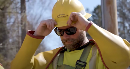 Utility worker putting on hardhat