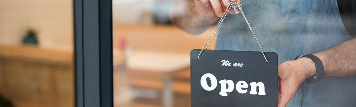 Small business owner hanging open sign