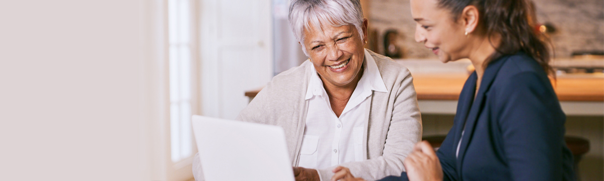 Family smiling while looking at laptop computer