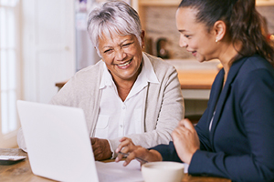 Family smiling while looking at laptop computer