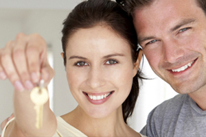 Smiling couple with key to new home