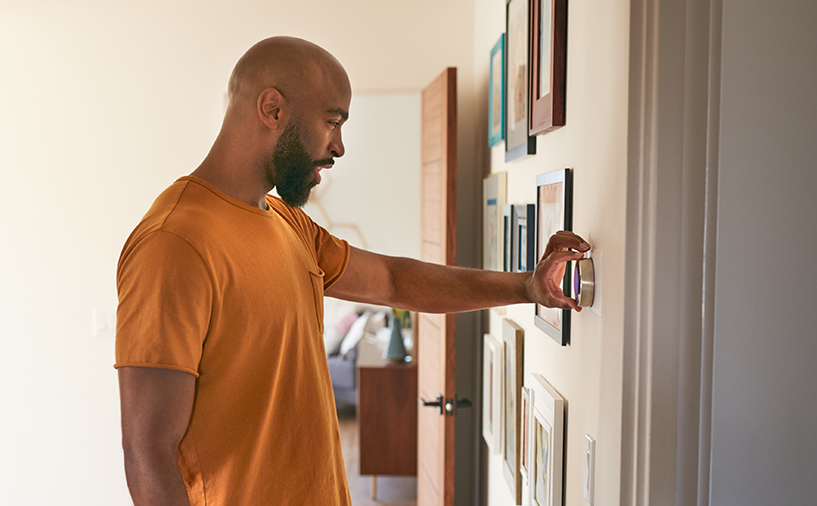 Man adjusting thermostat